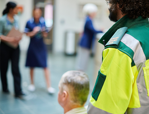 Paramedic pushing man in wheelchair